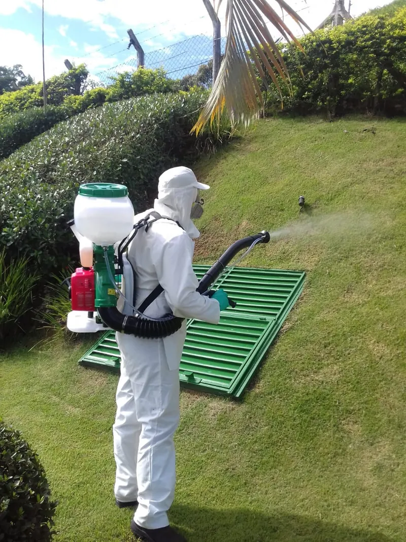 Técnico com EPI aplicando sanitização